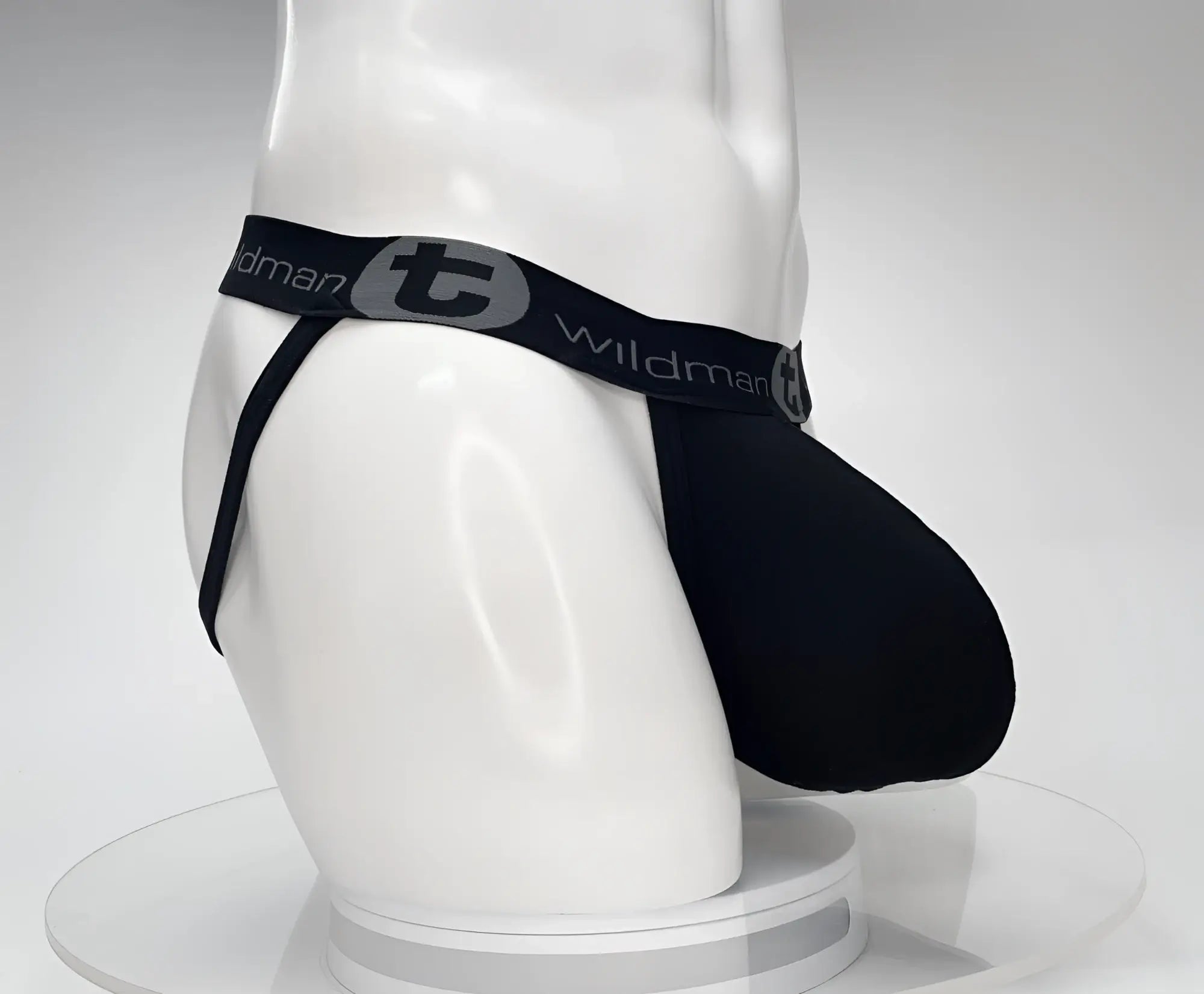 Black cotton jockstrap with a prominent front pouch on a white mannequin torso, featuring a branded elastic waistband.