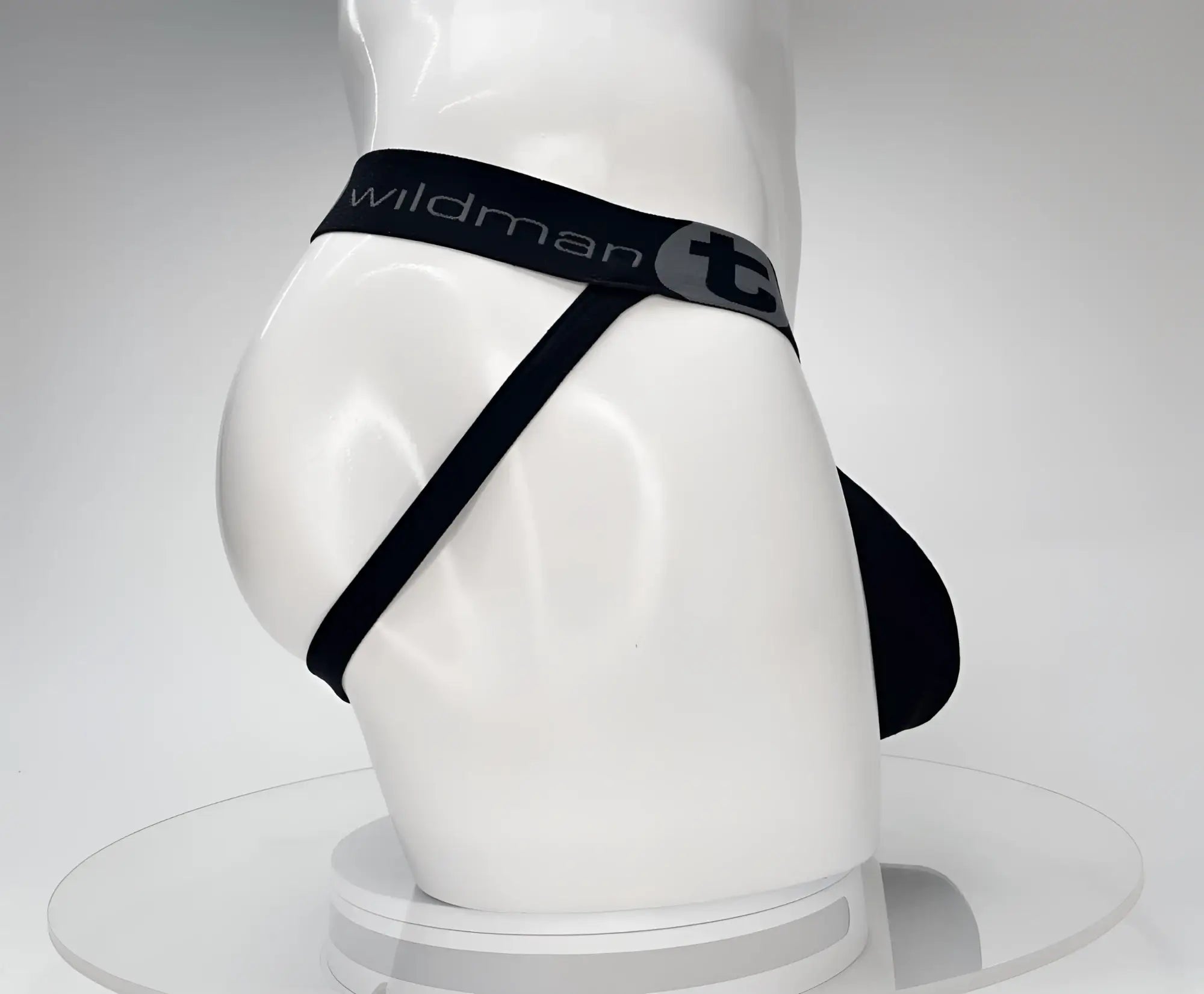 Black WildmanT cotton jockstrap on a white mannequin, featuring a branded elastic waistband and thin leg straps.