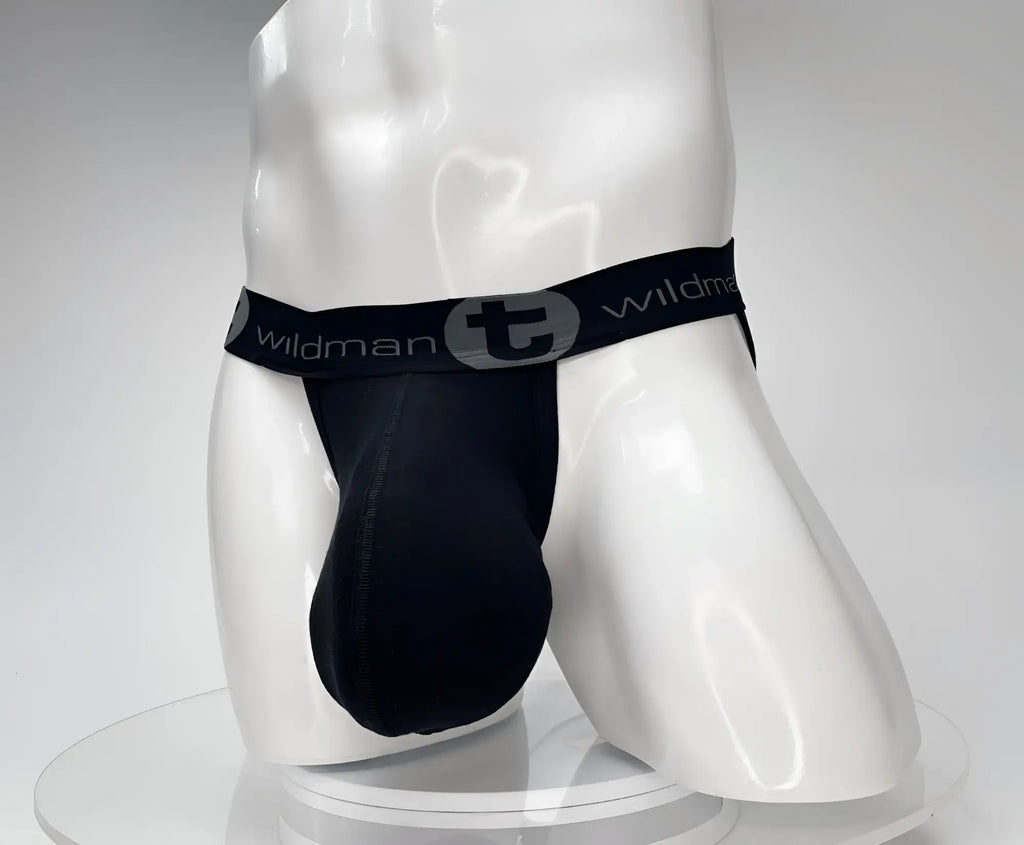 Black WildmanT cotton jockstrap with a contoured pouch on a white mannequin, featuring a logo-branded elastic waistband.