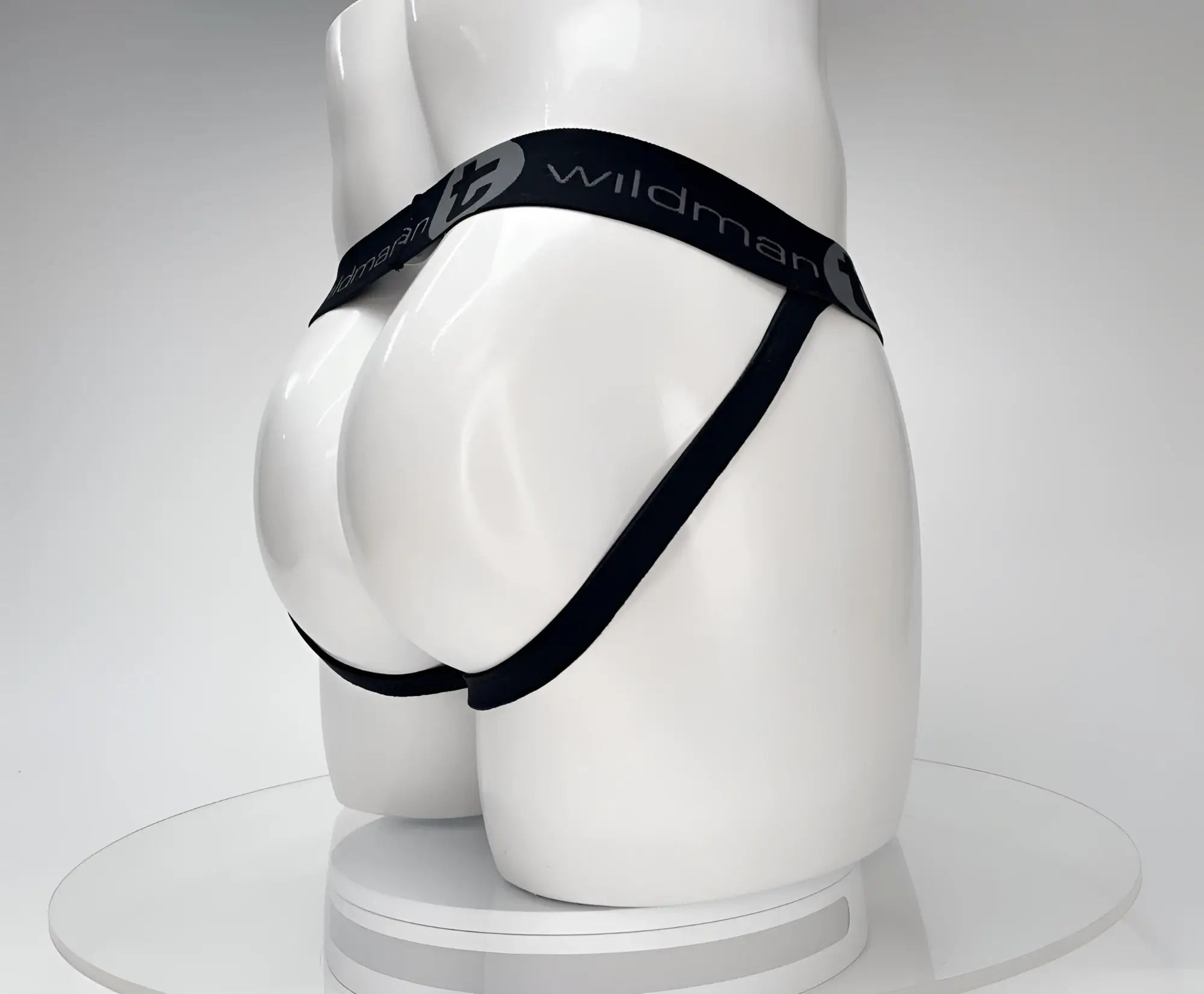 Black jockstrap on a white mannequin, featuring a branded elastic waistband with "WildmanT" logo text.