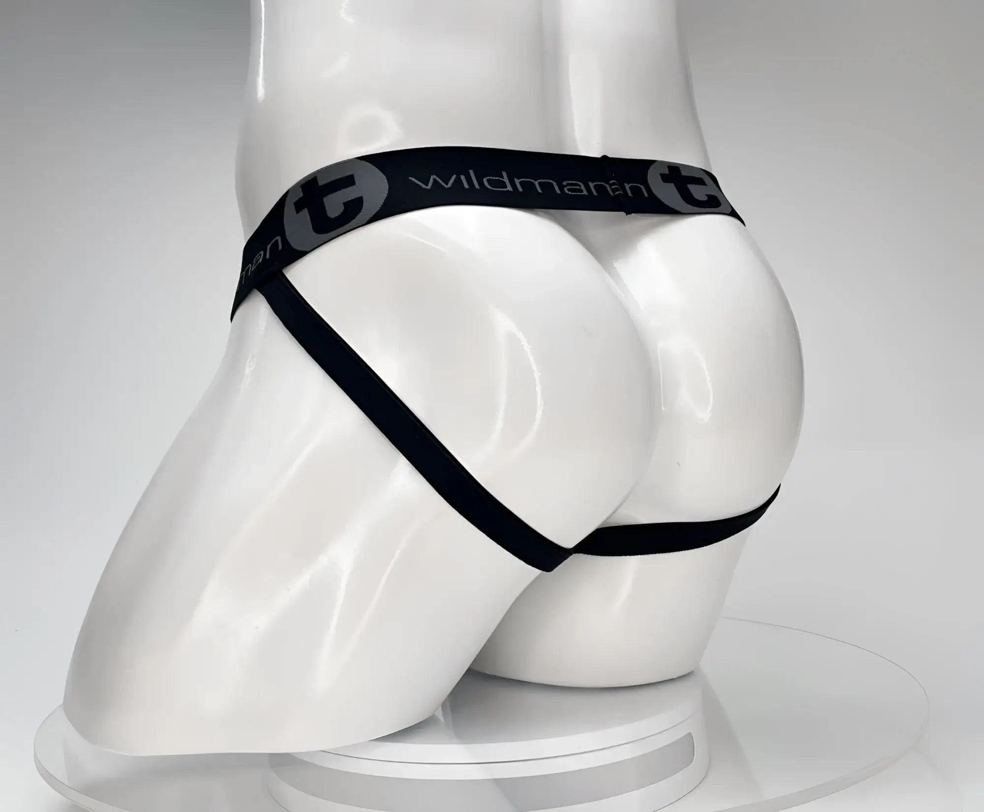 Black WildmanT jockstrap on a white mannequin, featuring a branded waistband and leg straps against a plain background.