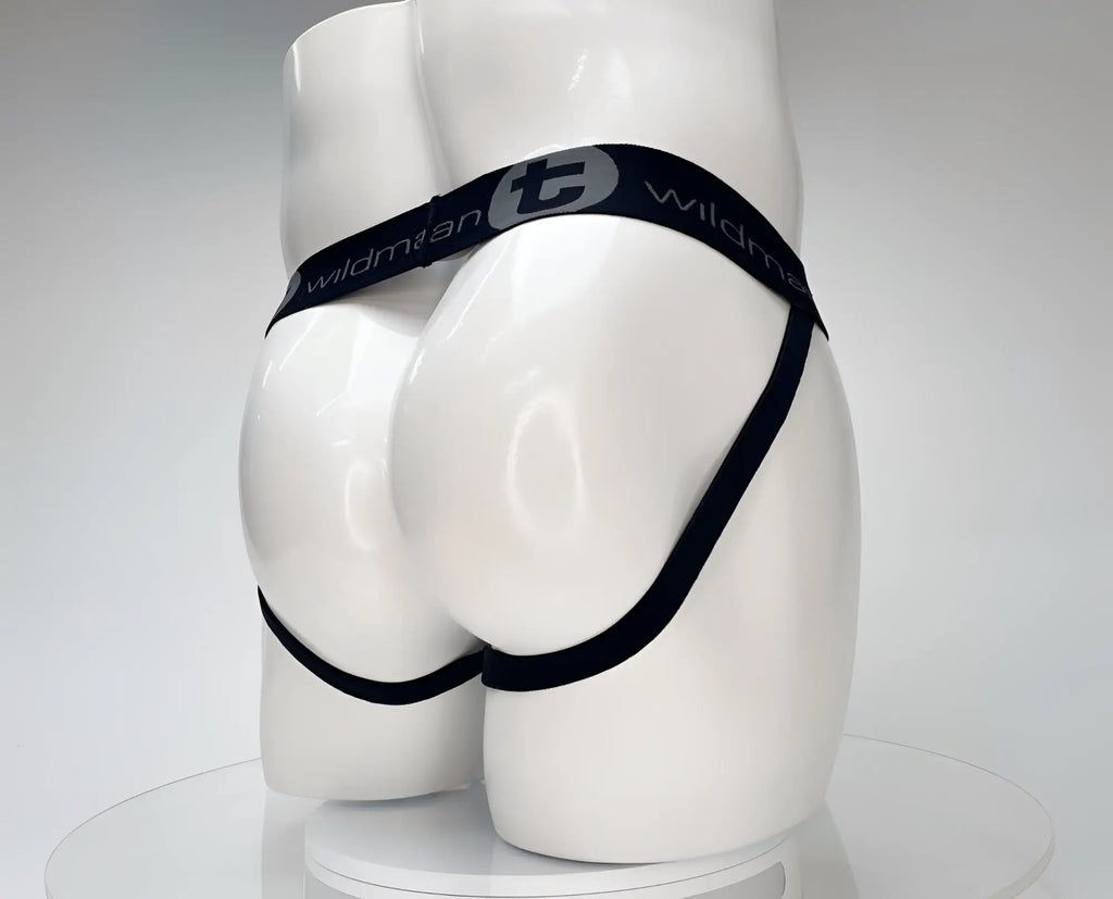 White WildmanT jockstrap on a mannequin, featuring a black branded waistband and leg straps.