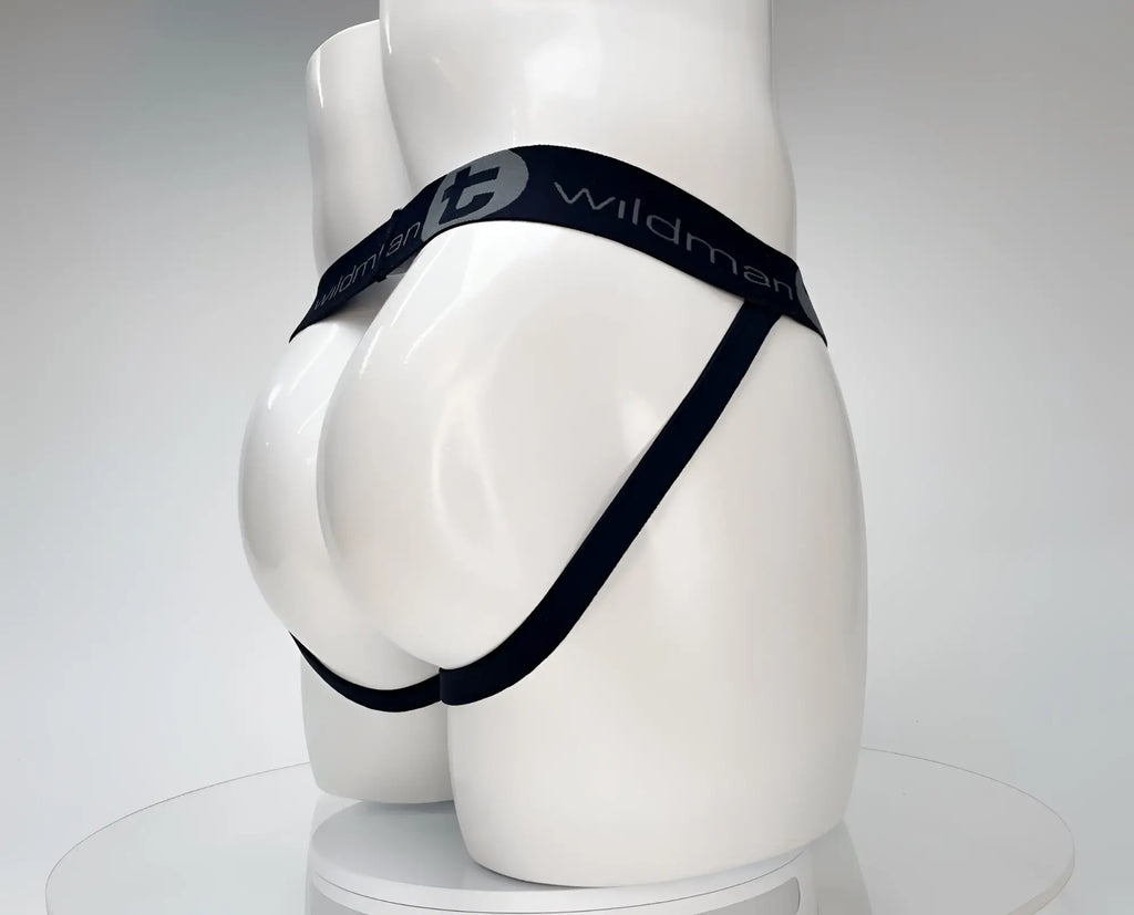 White WildmanT jockstrap on a mannequin, featuring a black branded elastic waistband and side straps.