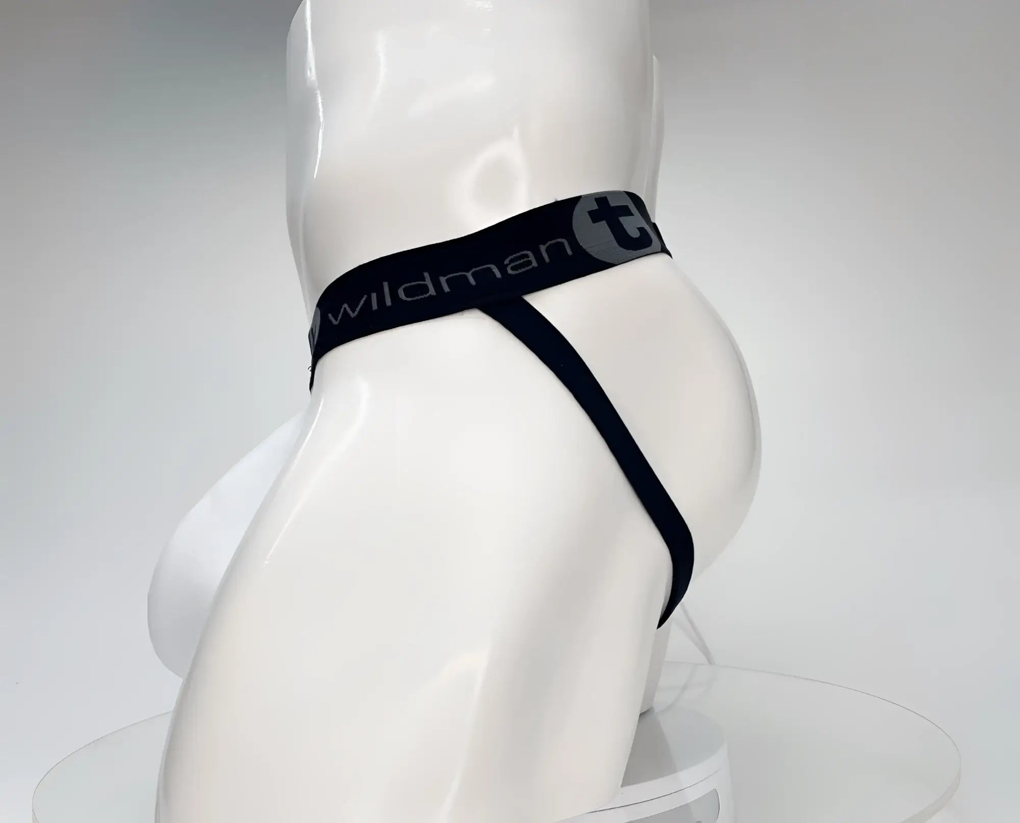 White jockstrap with a black waistband featuring the "WildmanT" logo on a mannequin torso, side profile view.