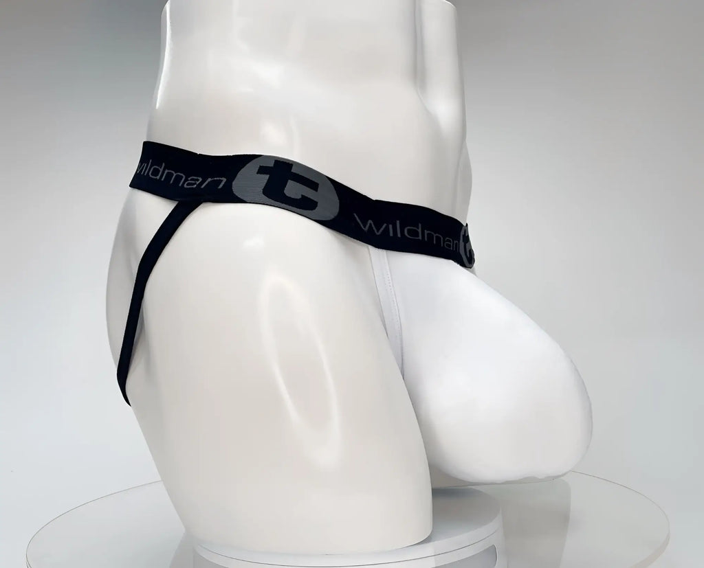 White cotton jockstrap with a prominent pouch, black branded elastic waistband with "Wildman" and logo, side view.