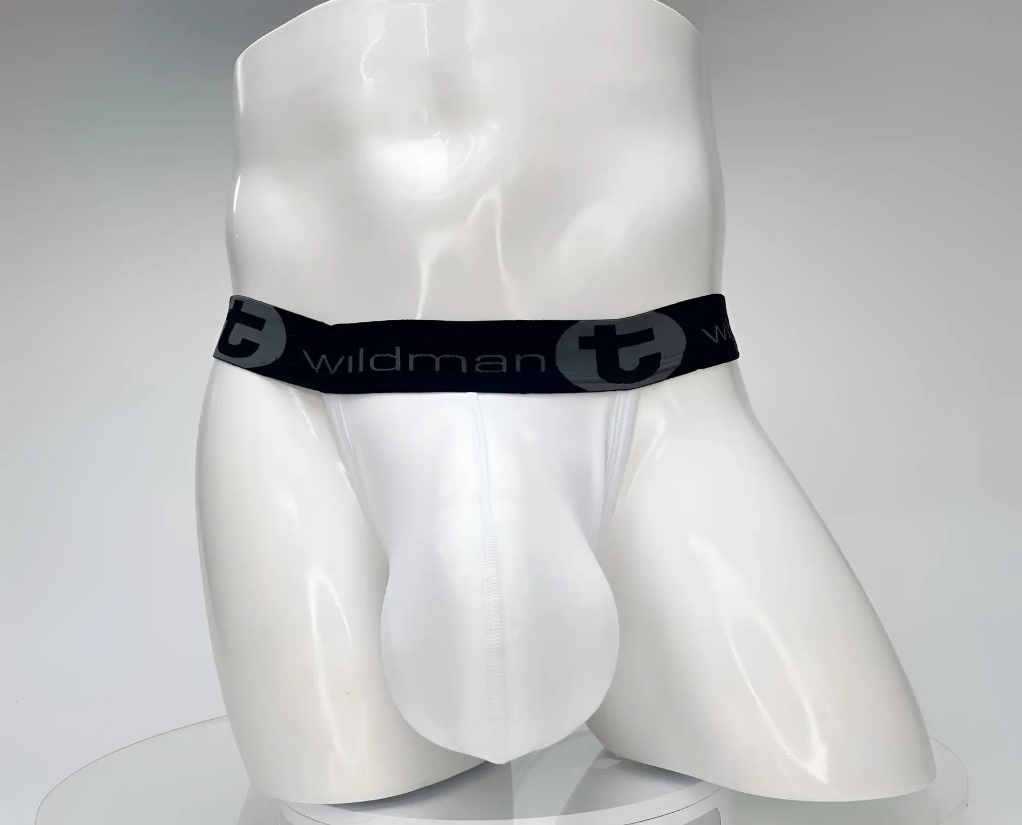 White cotton jockstrap with a large, contoured pouch and a black waistband featuring "WildmanT" branding.