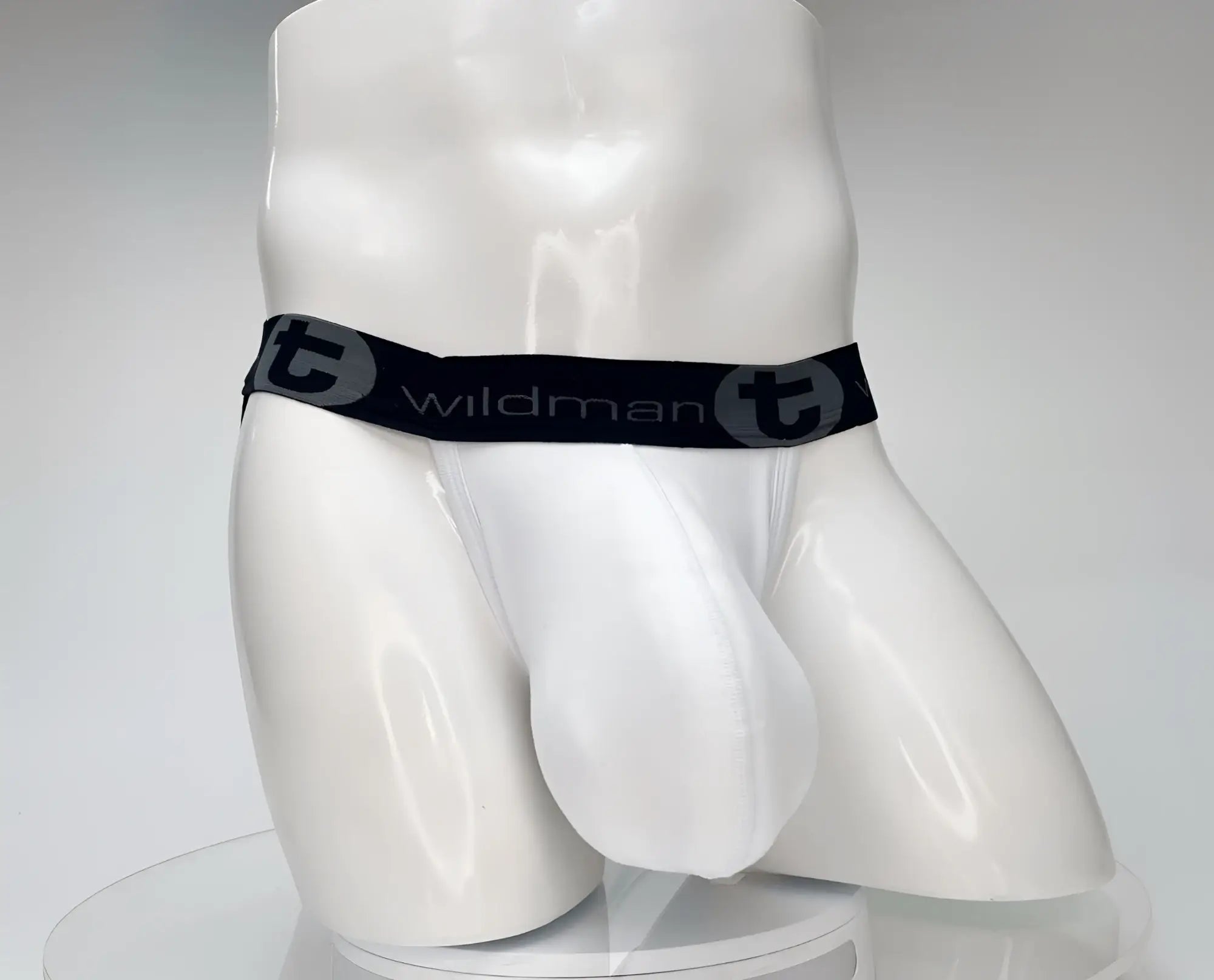 White WildmanT cotton jockstrap with a contoured front pouch and black elastic waistband featuring the brand logo.