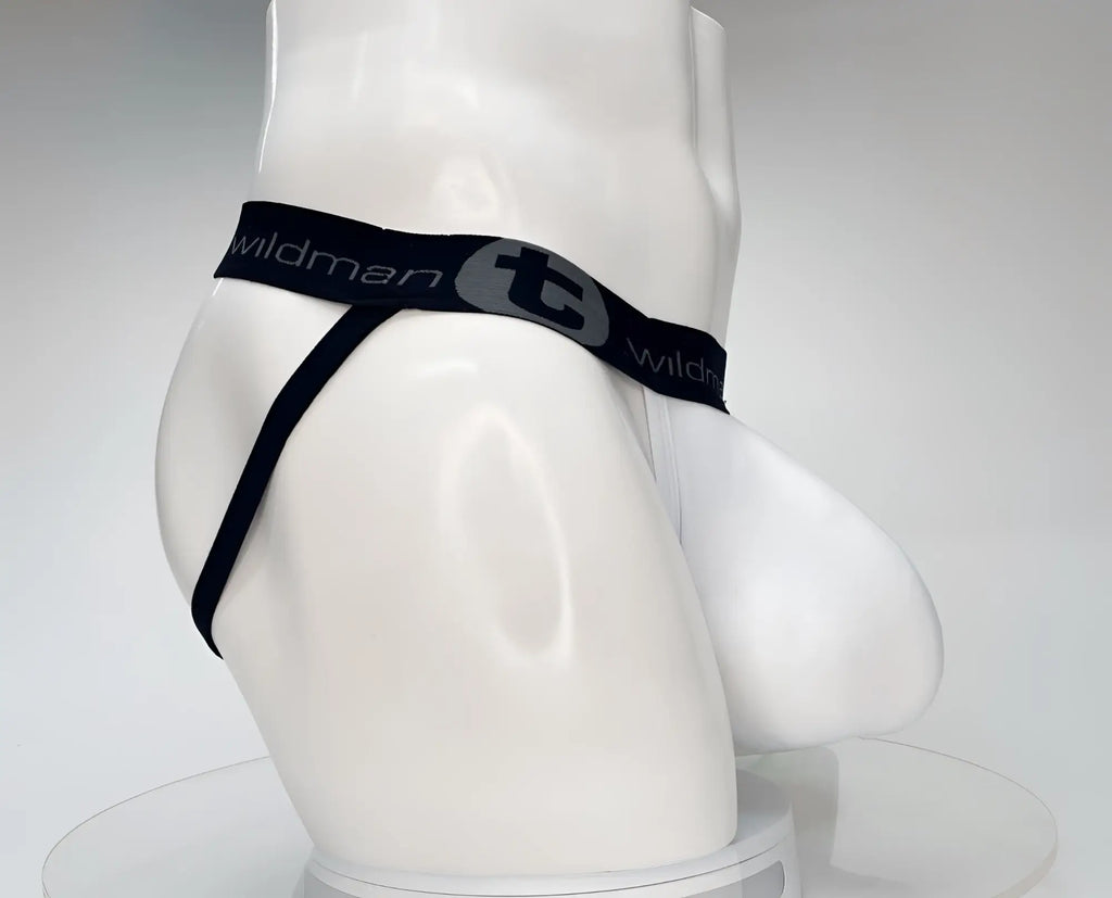 White jockstrap on a mannequin with a large pouch and a black branded waistband featuring the WildmanT logo.