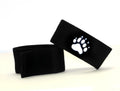 Two black adjustable fabric cock rings featuring a white embroidered bear paw print emblem.