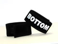 Black fabric cock ring with a Velcro closure, featuring the word "BOTTOM" in bold white lettering.