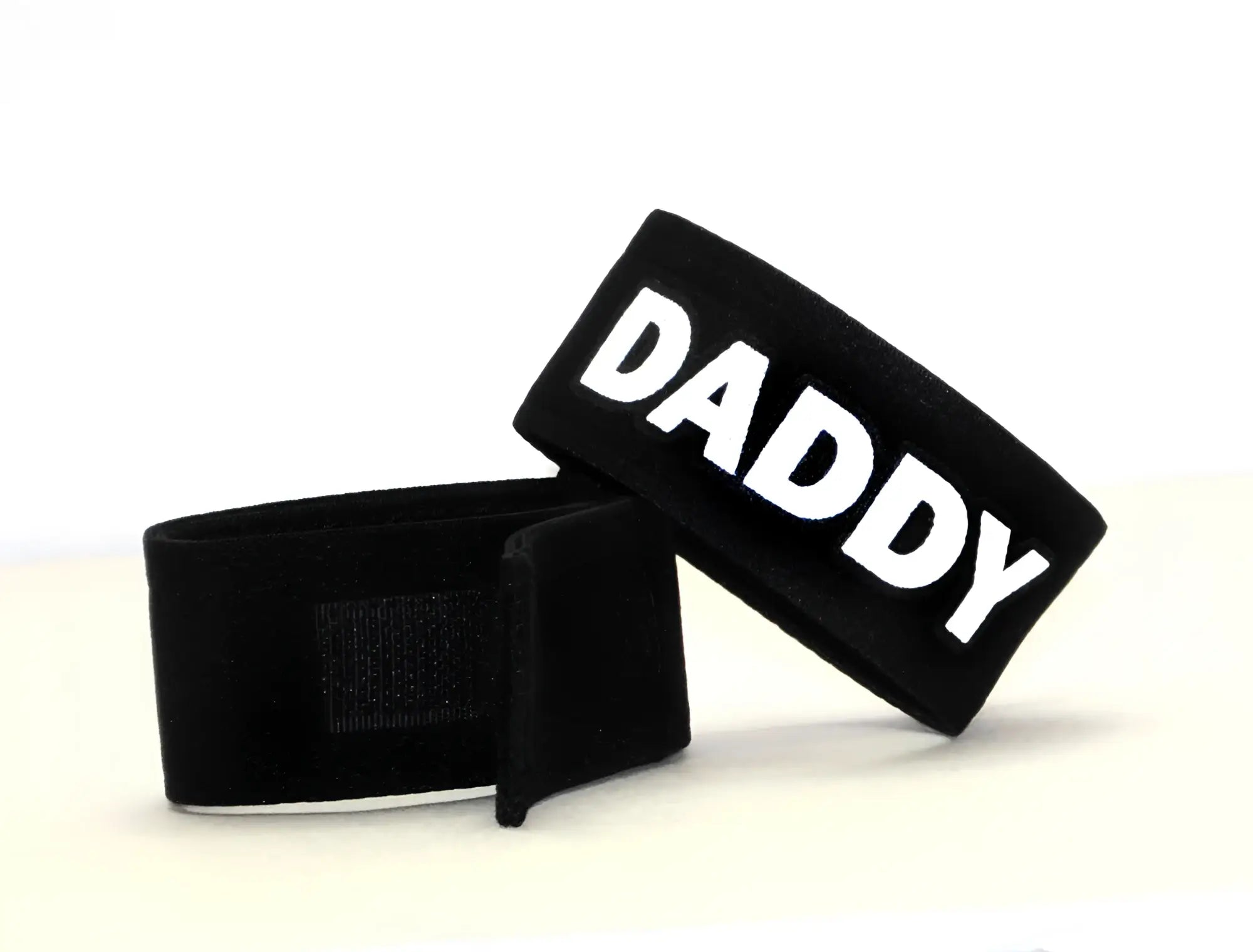 Two black adjustable fabric cock rings with white "DADDY" text and Velcro closures against a white background.