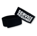 Black elastic cock ring with velcro closure and "SERVICE REQUIRED" printed in bold white text.
