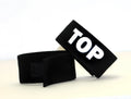 Black fabric adjustable cock ring with "TOP" in bold white lettering, featuring a velcro closure.