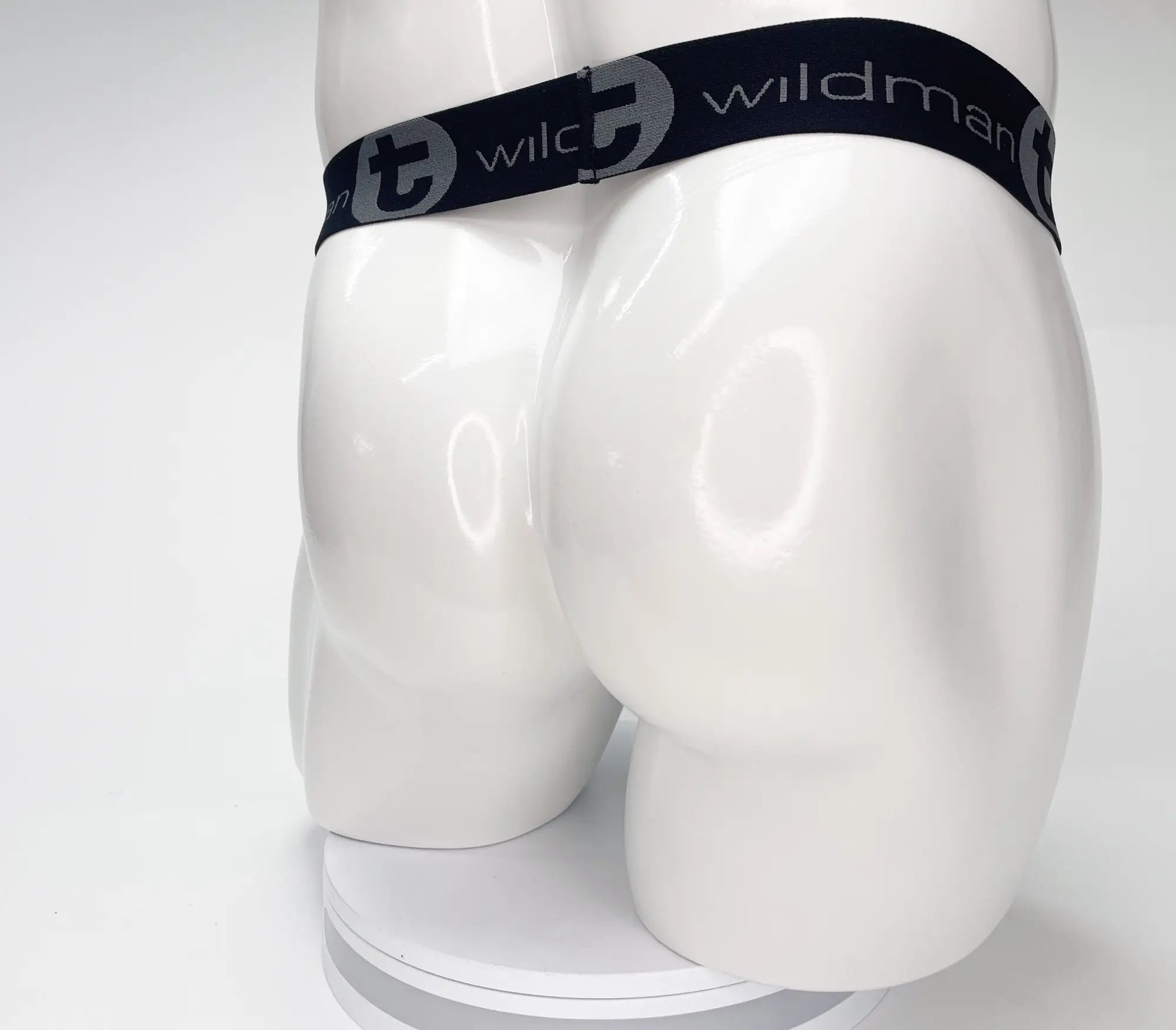 Black WildmanT strapless pouch featuring a black branded elastic waistband with grey logos on a white mannequin torso.