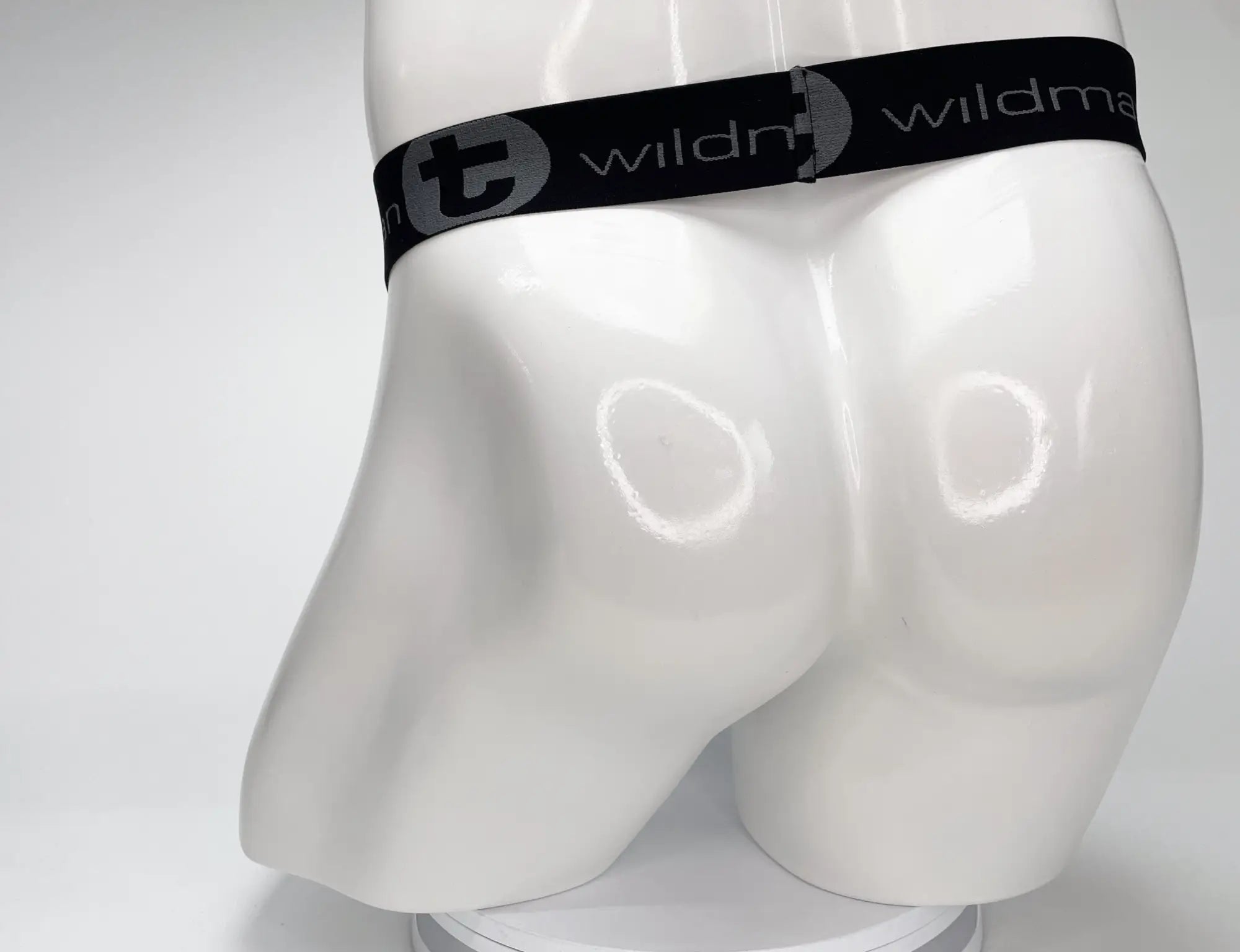 White male mannequin wearing a WildmanT black elastic waistband with grey branded lettering.