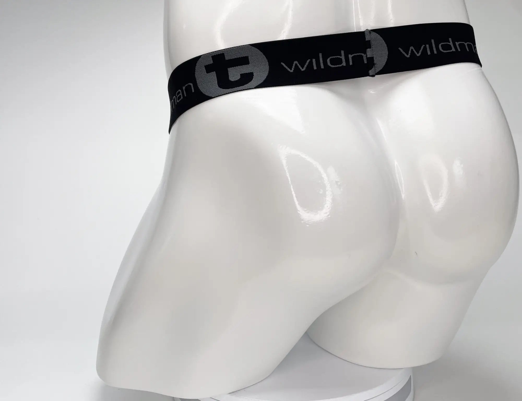 White WildmanT strapless pouch on a mannequin, featuring a black branded elastic waistband with the WildmanT logo.
