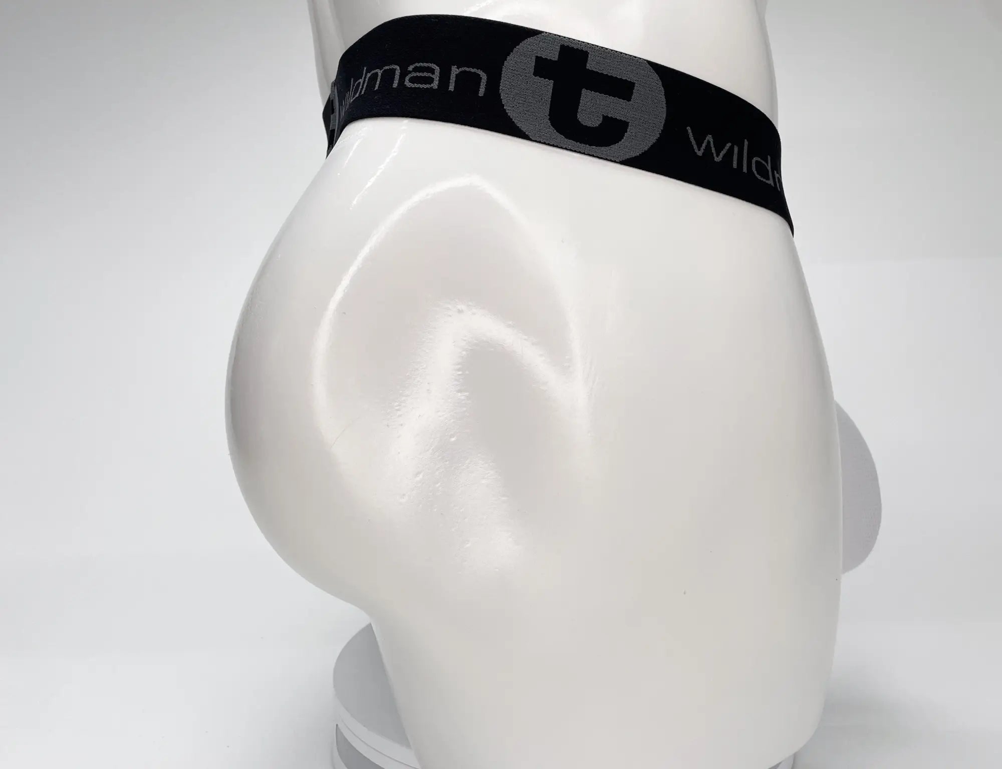 White WildmanT mesh strapless pouch worn on a white mannequin with a black elastic waistband featuring logo branding.