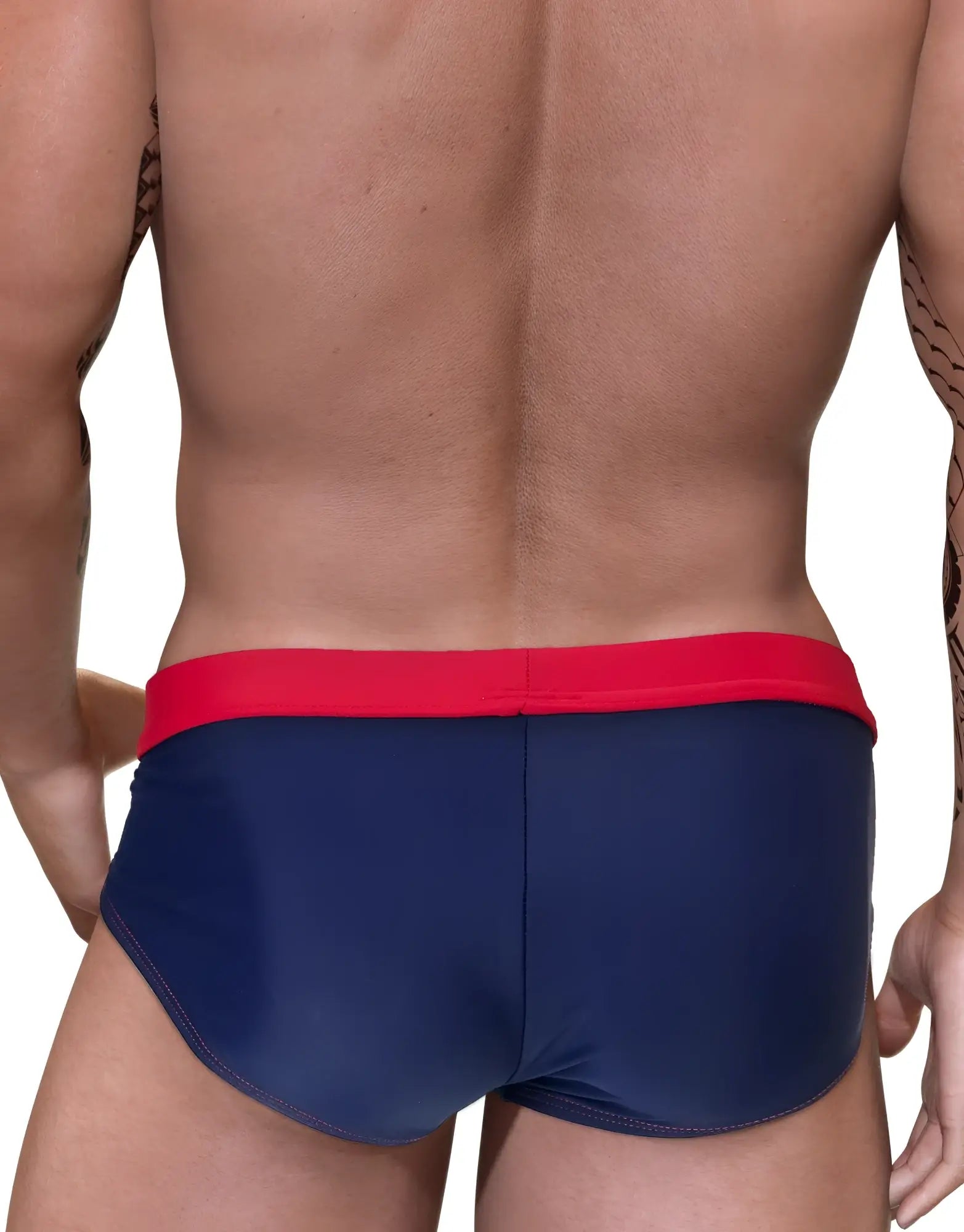 Navy blue swim trunks with a bright red waistband and red contrast stitching worn by a muscular man.