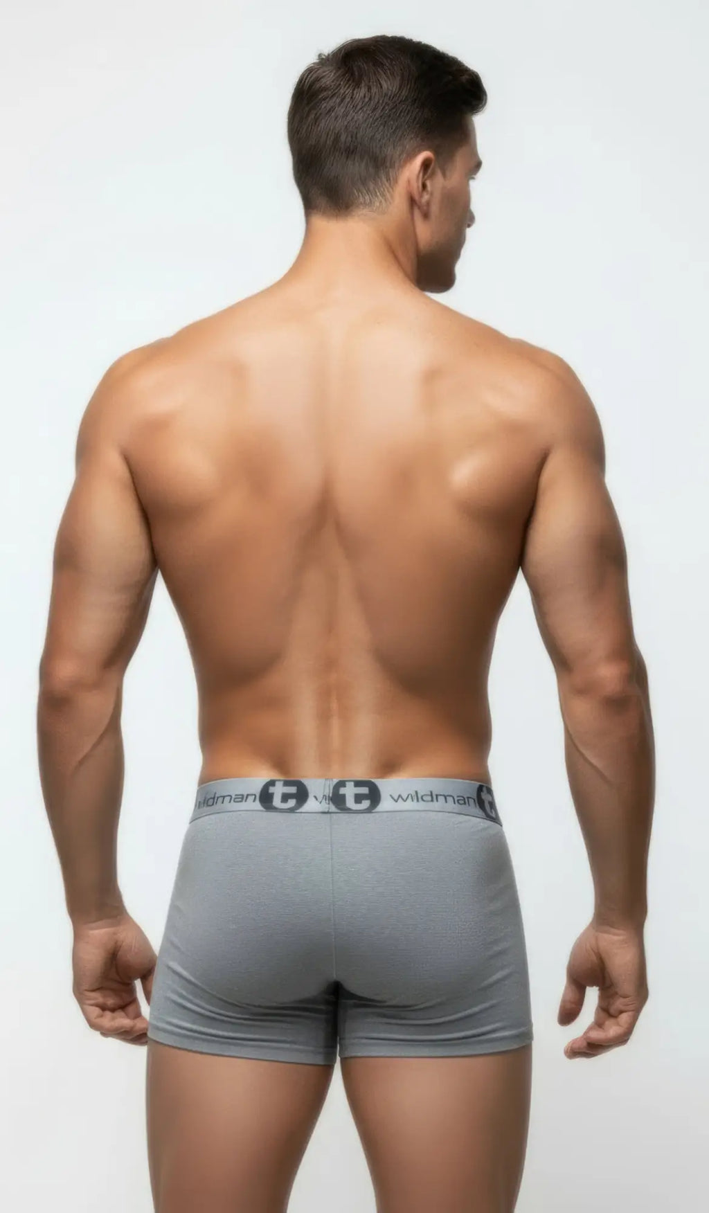 Back view of a muscular man wearing gray WildmanT modal boxer briefs with a logo-branded elastic waistband.