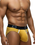 Gold modal pouch briefs with white trim details and a black branded WildmanT elastic waistband on a fit male model.