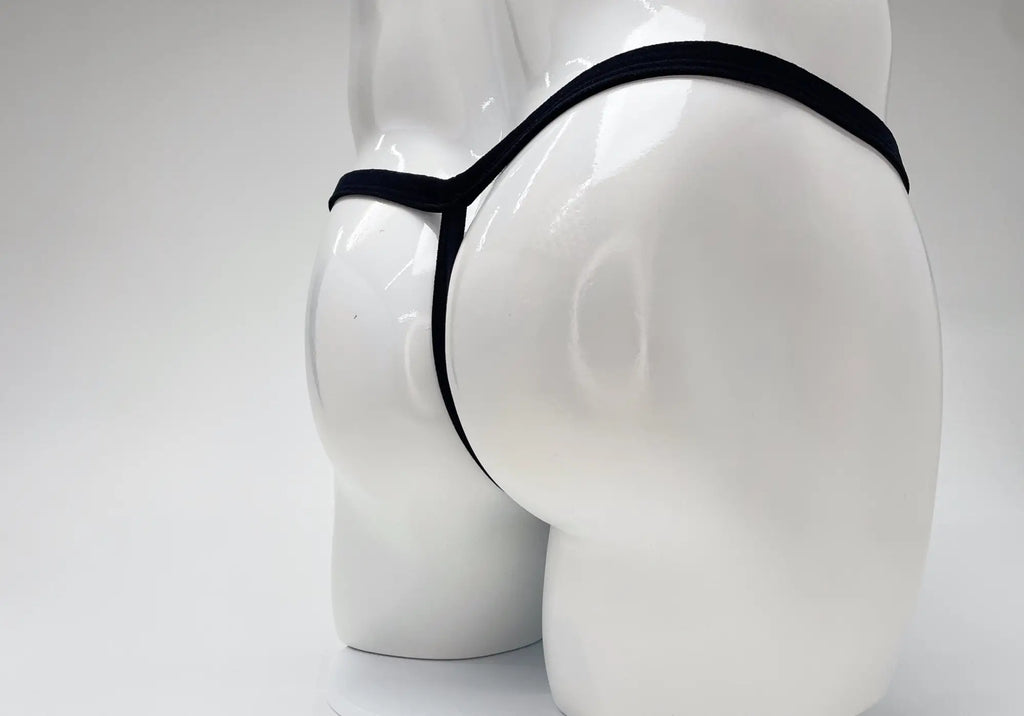 Black thong with a thin waistband on a glossy white male mannequin torso against a white background.