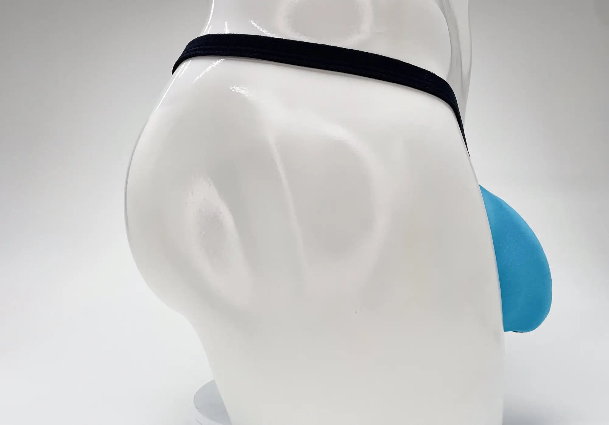 Baby blue micro thong with a prominent pouch and thin black waistband, displayed on a white mannequin.