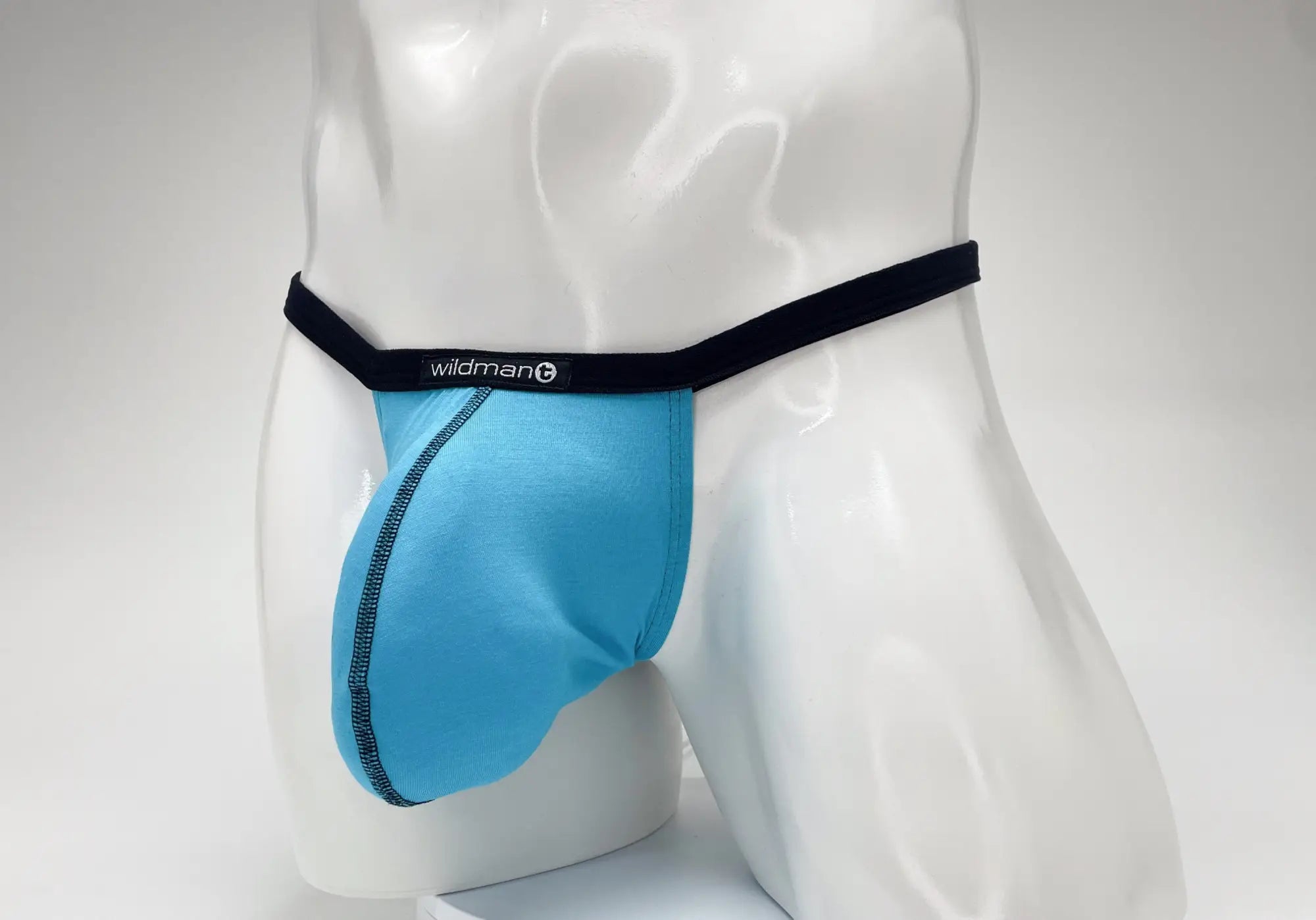 Baby blue WildmanT micro thong with a prominent pouch, black waistband, and logo tag on a white male mannequin.