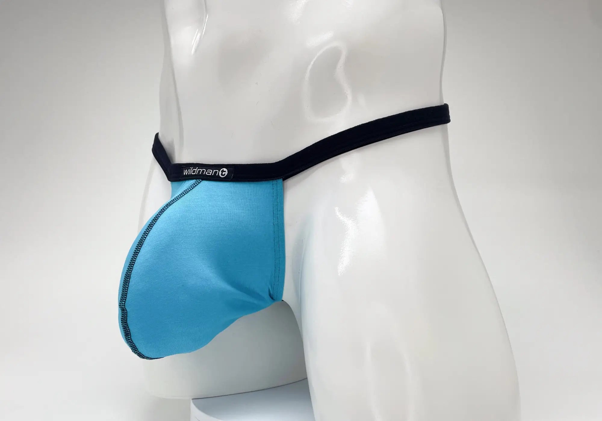 Baby blue micro thong with a large pouch, black waistband, and WildmanT logo, modeled on a white mannequin.