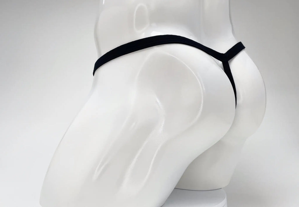 Black thong on a white mannequin torso, seen from behind.