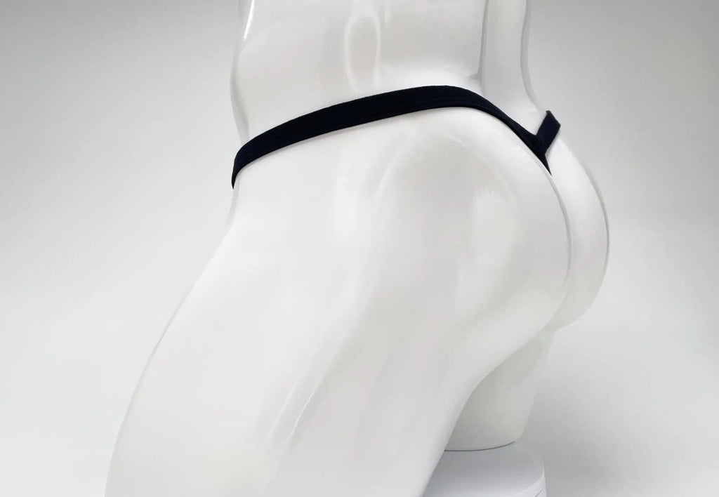 Black WildmanT modal micro thong on a white mannequin, showing the thin waistband and minimalist rear coverage.