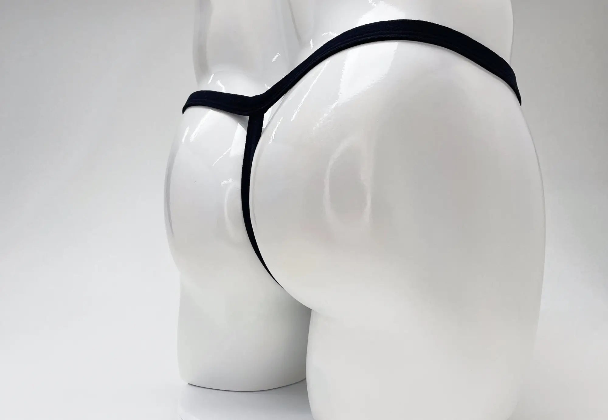 Black WildmanT modal micro thong on a white mannequin, showing a minimalist T-back design.
