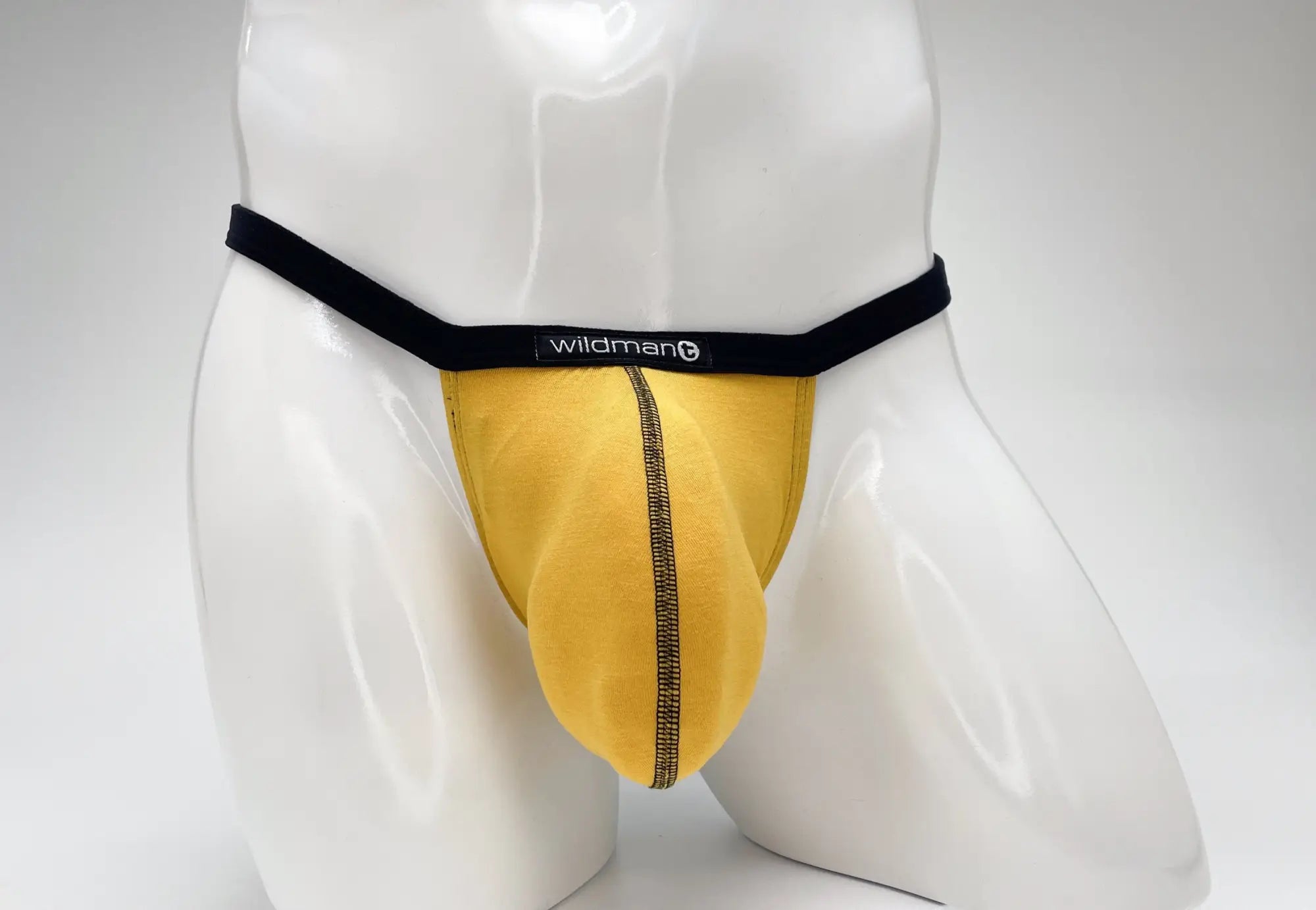 WildmanT gold modal micro thong with black waistband and center seam on a white mannequin torso.