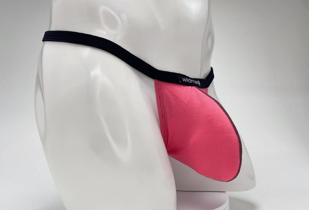 WildmanT pink modal micro thong with a prominent big boy pouch and black waistband on a white mannequin torso.