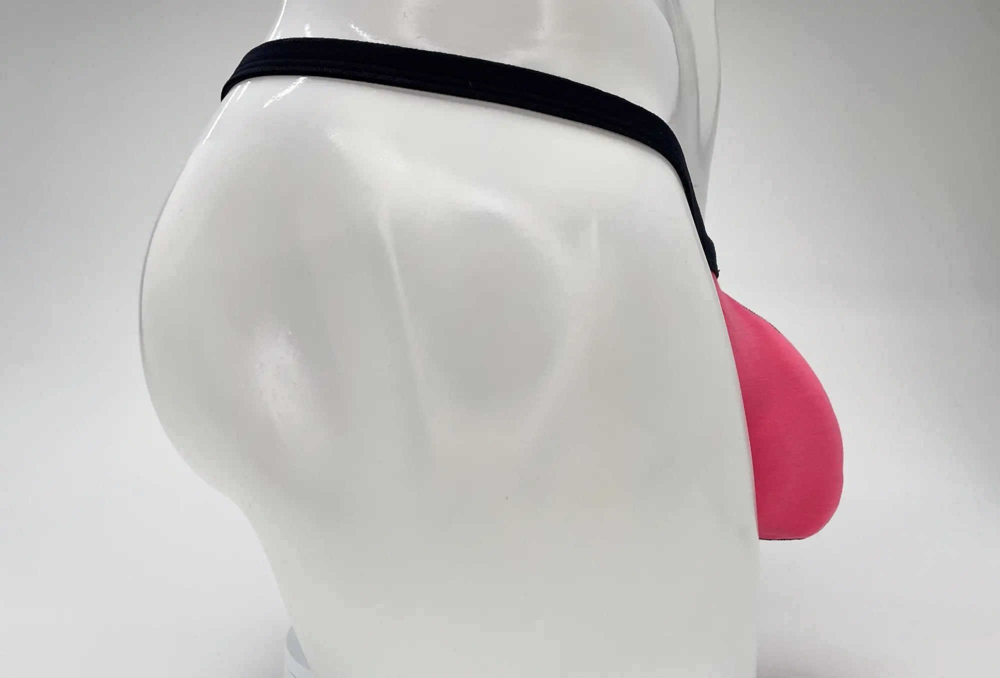 Pink WildmanT Modal micro thong with a prominent pouch, worn on a white mannequin against a white background.
