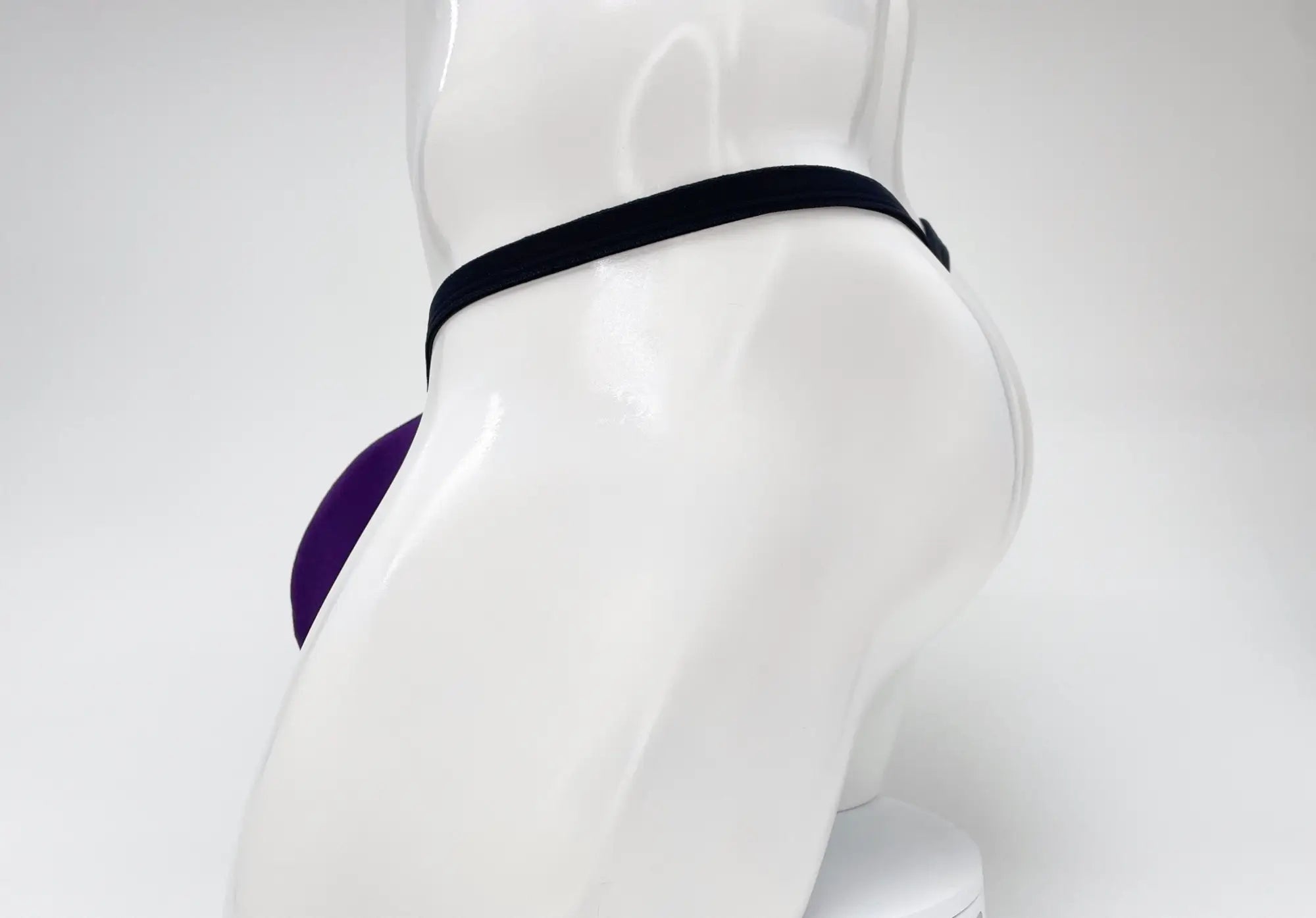 WildmanT purple modal micro thong with a big boy pouch on a white male mannequin, side view.
