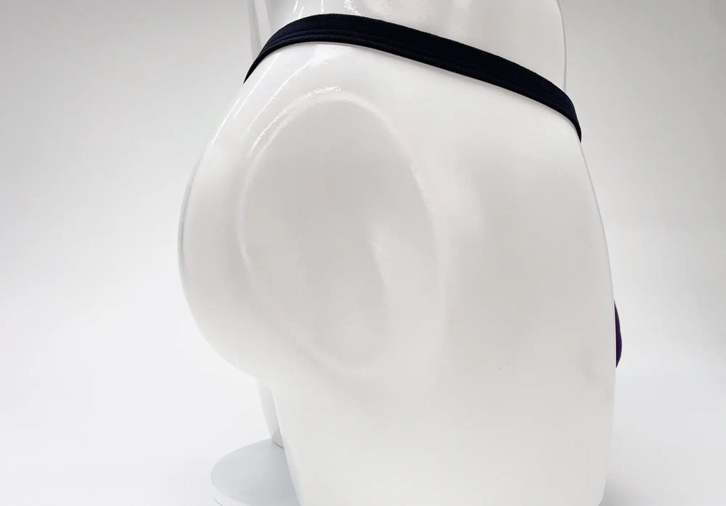 WildmanT purple modal micro thong with a thin black waistband on a white mannequin torso.