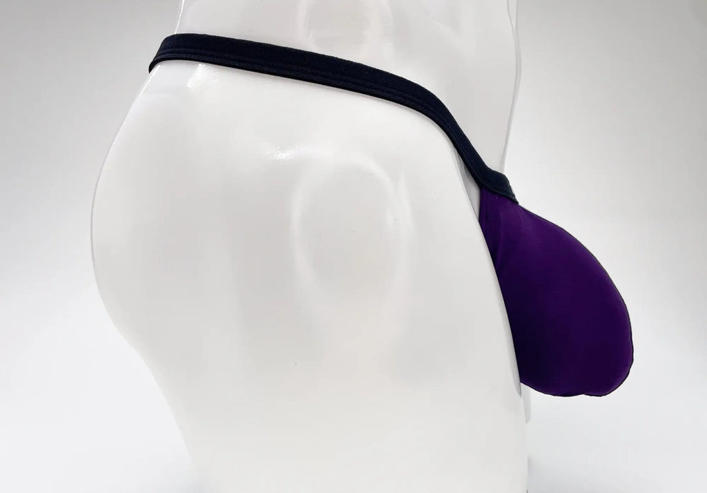WildmanT purple modal micro thong with a prominent Big Boy pouch and thin black waistband on a white mannequin.