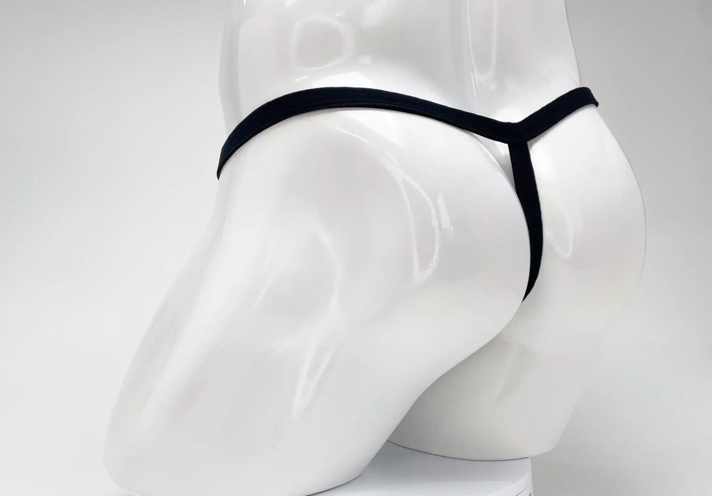 Rear view of a purple WildmanT Modal micro thong on a white mannequin torso, showing the thin waistband and T-back.