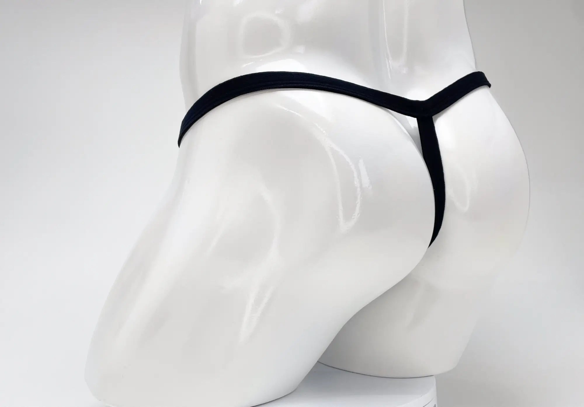 Rear view of a purple WildmanT Modal micro thong on a white mannequin torso, showing the thin waistband and T-back.
