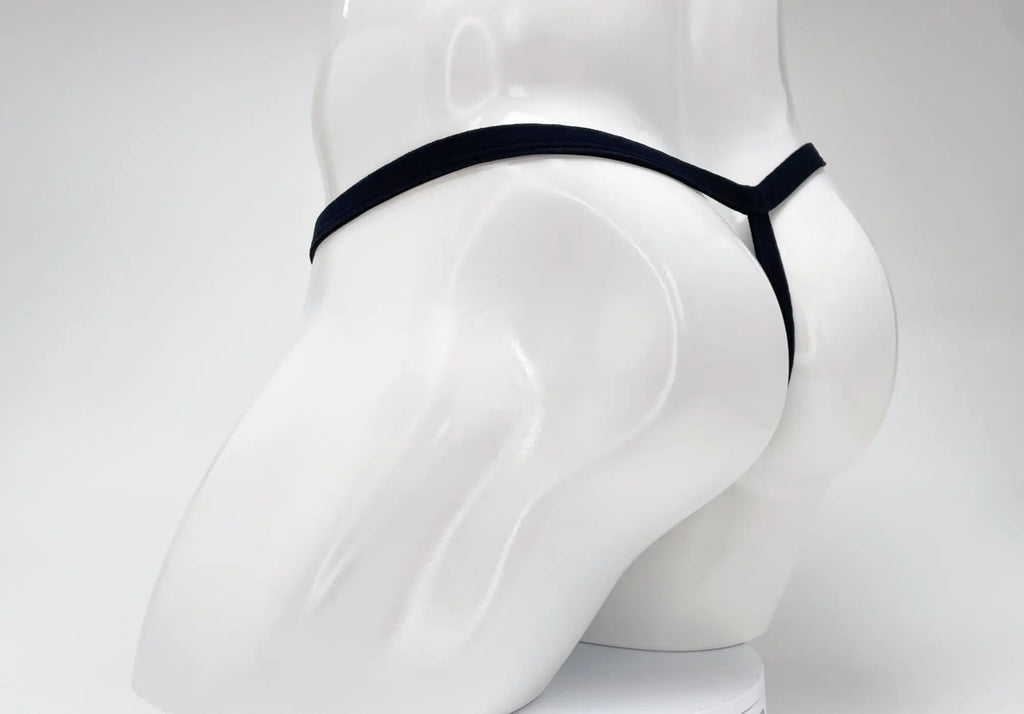 Purple WildmanT micro thong with a thin waistband and minimalist rear coverage on a white mannequin.