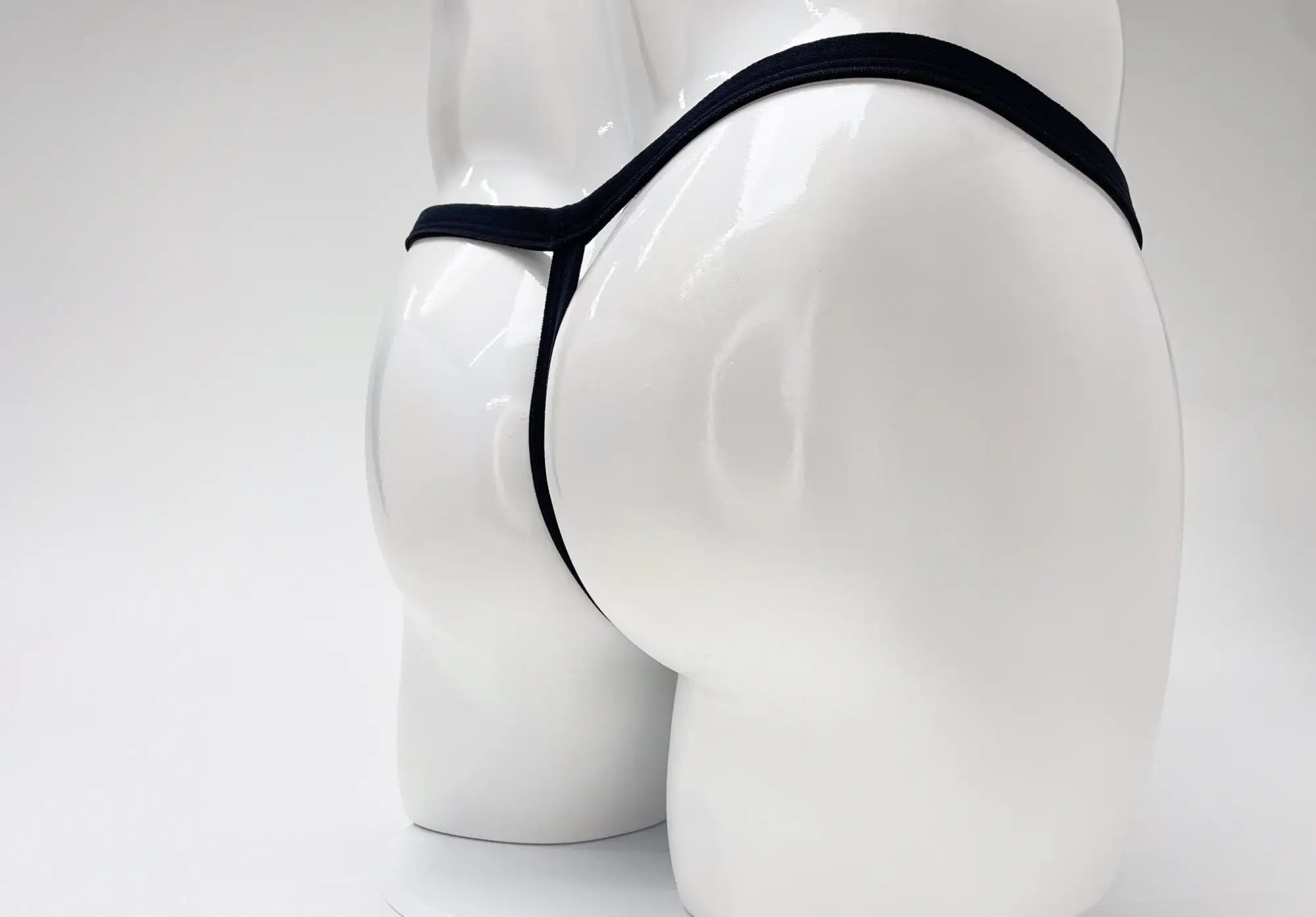 Back view of a white mannequin wearing a purple Modal Micro thong with a thin waistband and minimalist design.