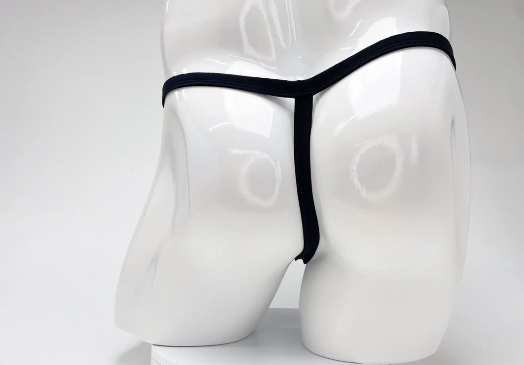 Back view of a white male mannequin wearing a black WildmanT micro thong with thin side straps.