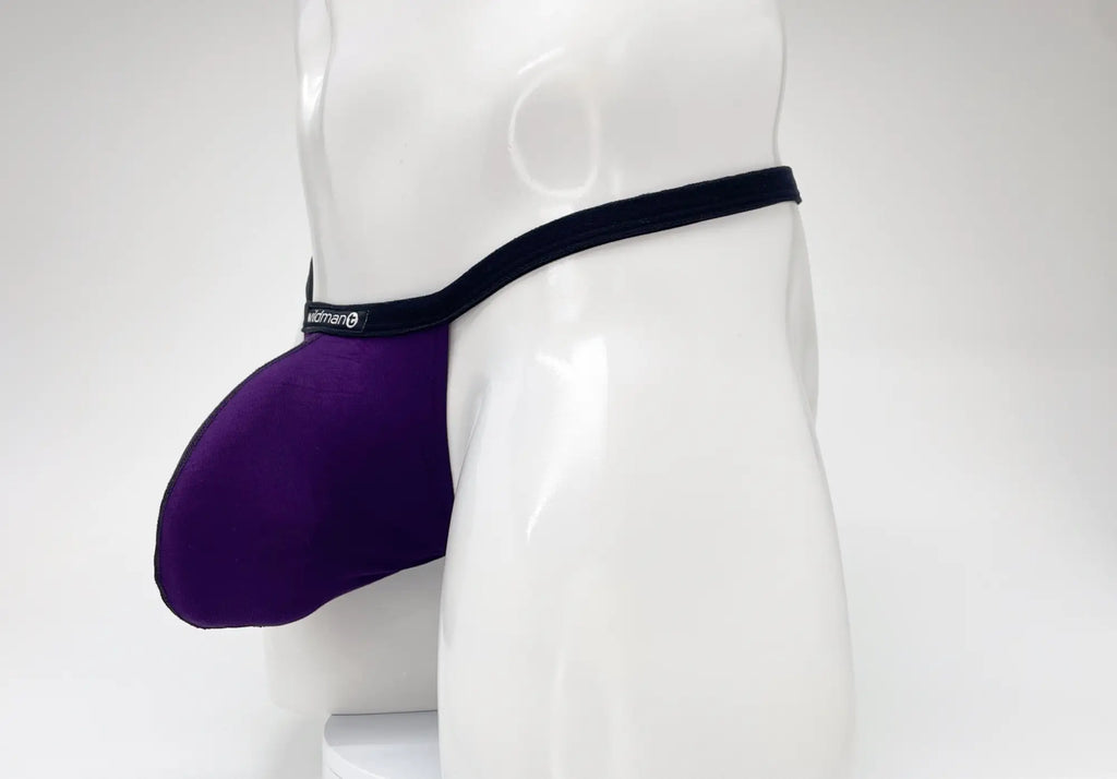 WildmanT purple modal micro thong with a prominent pouch, black waistband, and logo tag, worn on a white mannequin.