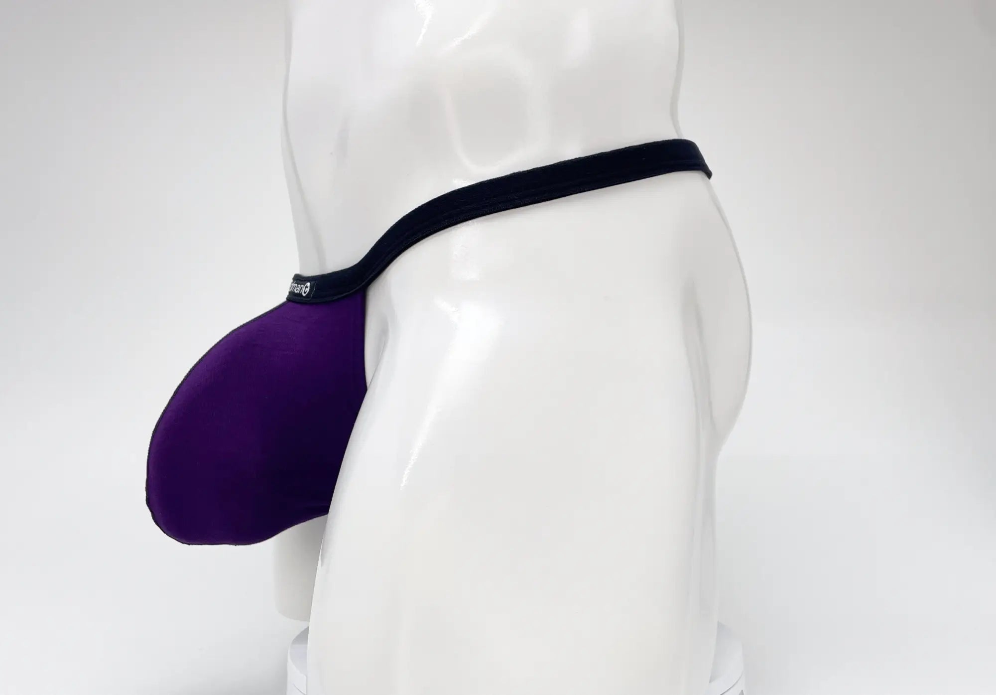 WildmanT purple modal micro thong with a prominent big boy pouch on a white mannequin torso.