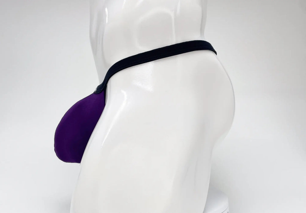 Side view of a purple WildmanT micro thong with a prominent pouch, displayed on a white mannequin torso.