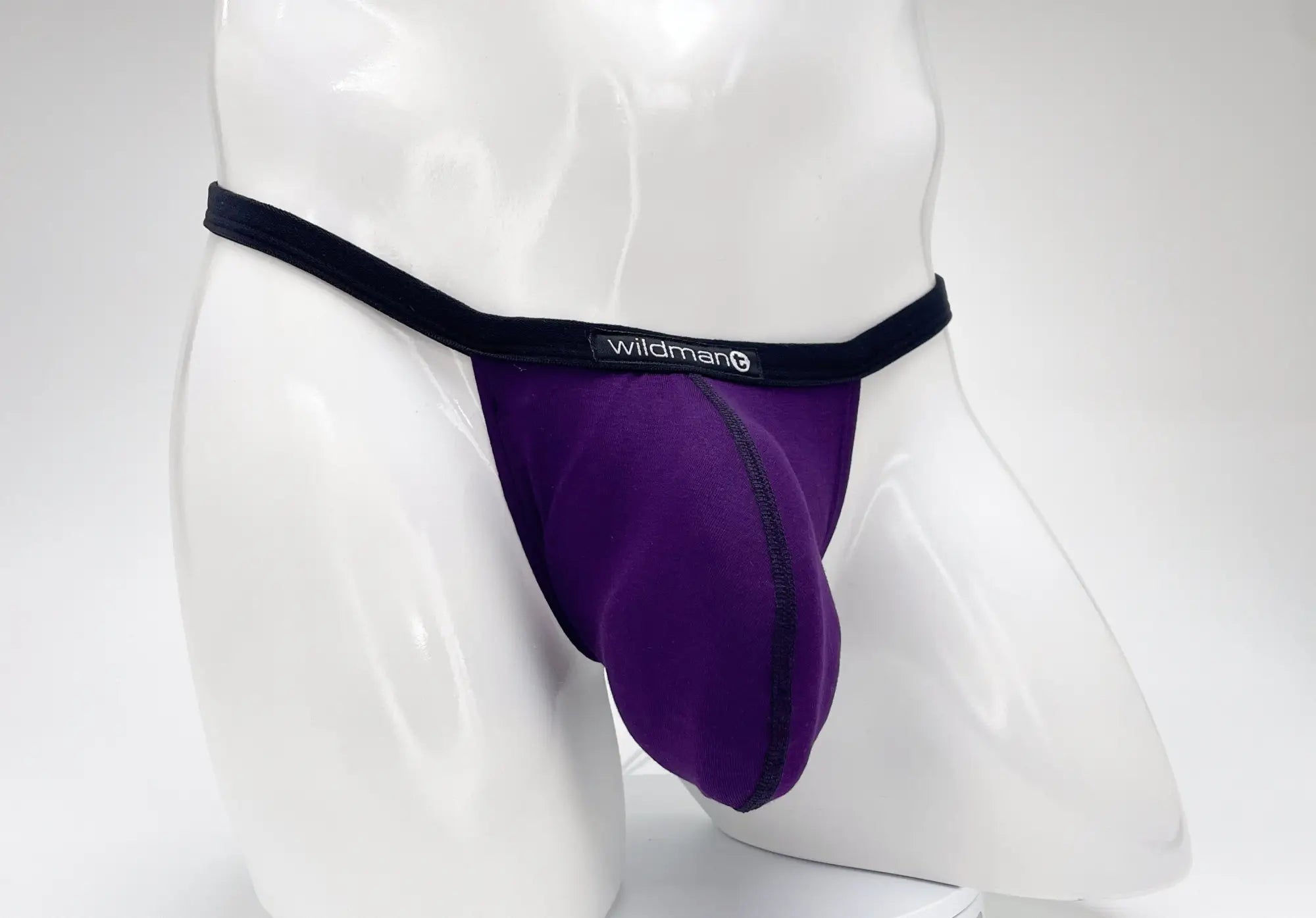Purple modal micro thong with a large pouch and black waistband featuring a WildmanT logo, displayed on a mannequin.