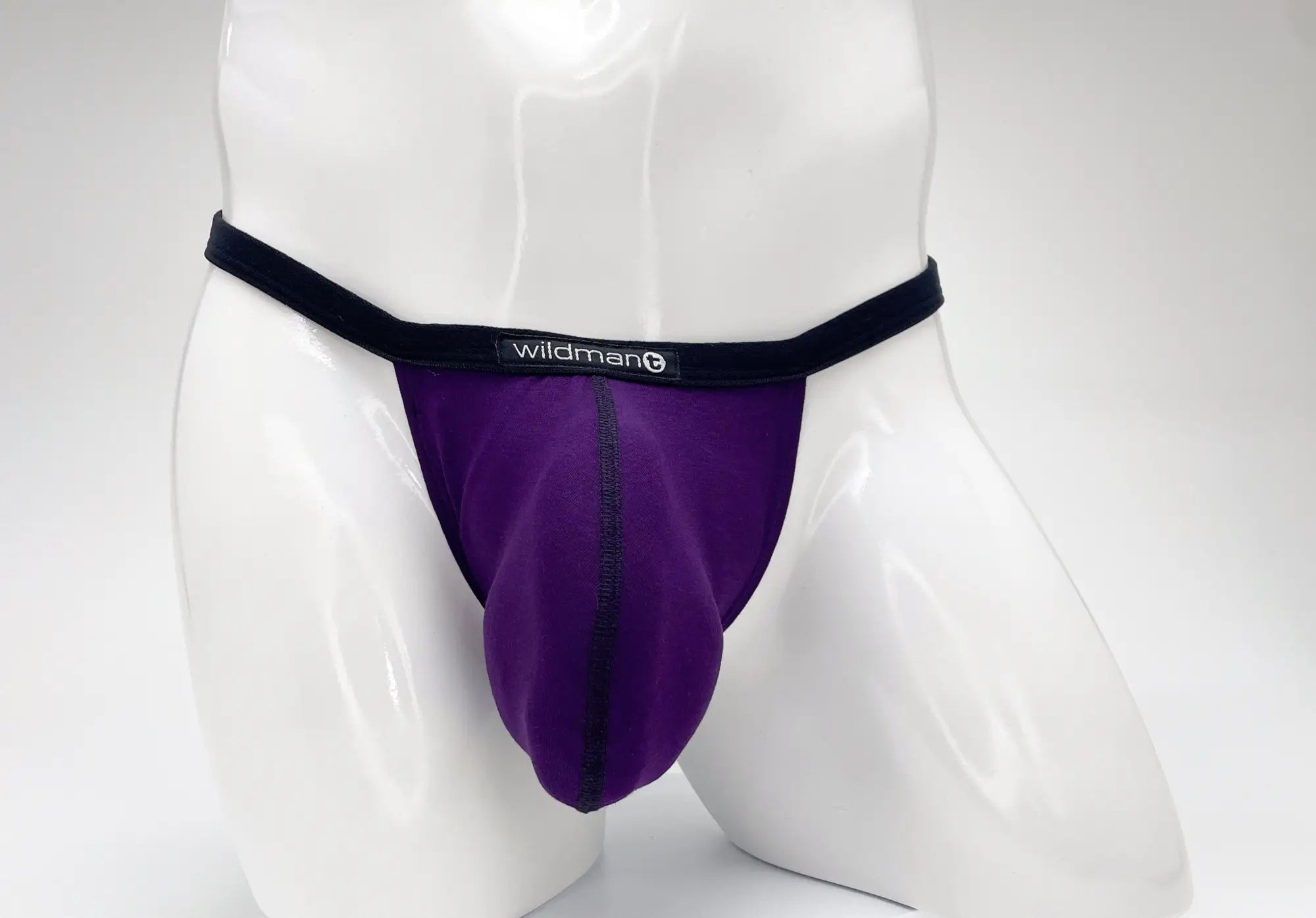 Purple WildmanT modal micro thong with a prominent pouch, black trim, and front logo on a white mannequin.