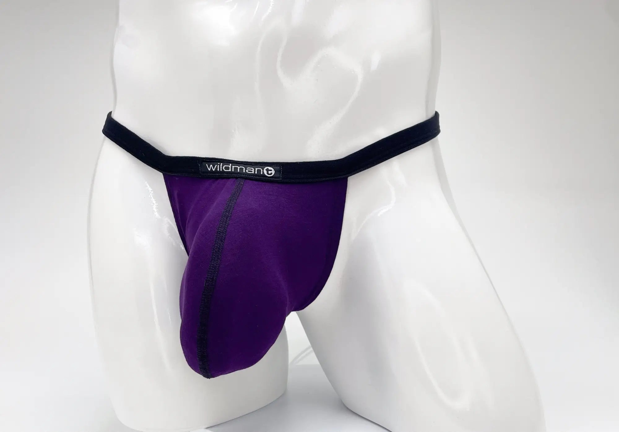 Purple WildmanT modal micro thong with a prominent pouch, black waistband, and logo centered on a white mannequin.