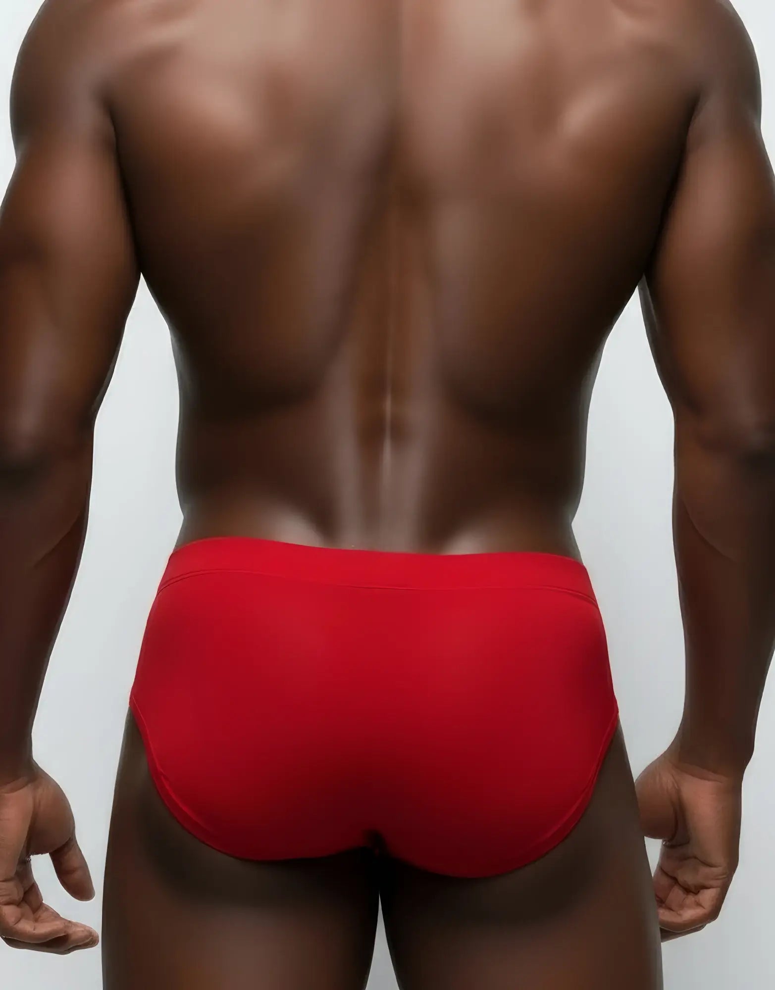 Back view of a man wearing red mesh briefs with a solid waistband.
