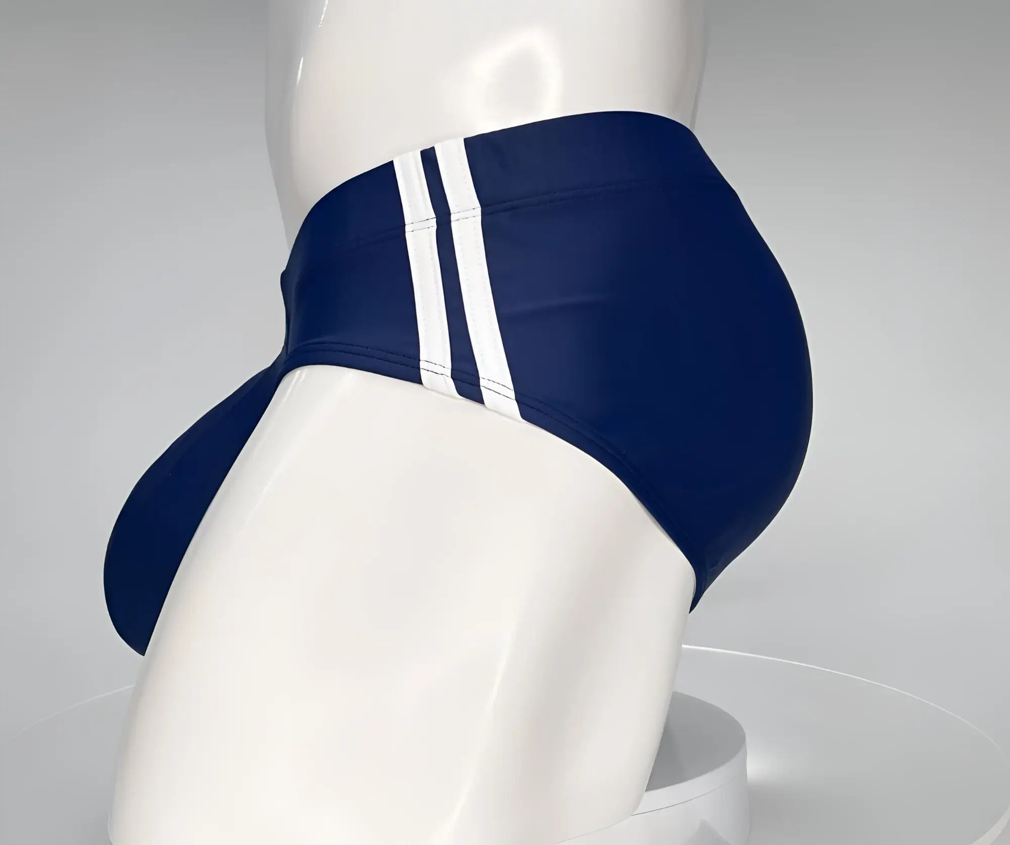 Navy blue WildmanT swim brief with two vertical white side stripes on a white mannequin.